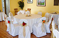 White chair coverings with flower sashes