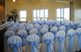 White chair coverings with light blue sashes