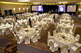 Large venue showing white and gold chair cover treatments