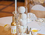 Gold bottle, glass vase with crystal and white balls as a centrepiece