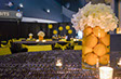 Lit candles and glass centrepiece filled with yellow lemons and topped with white flower