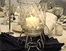 Beautifully set table with glass candle holder and place settings