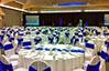Presentation event with white chair covers and blue sashes.