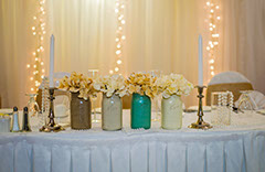 Mason jars on decorated wedding table.