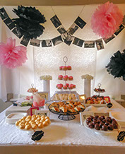 Social party with prepared table of food and flowers with overhanging photos